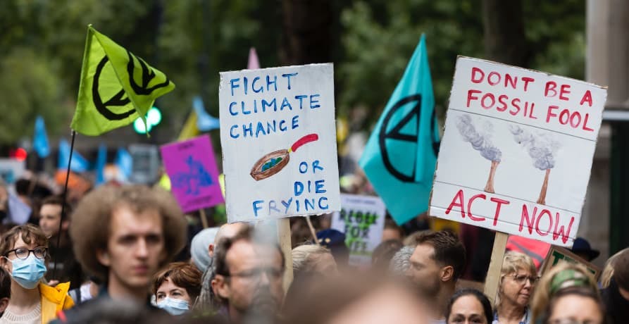 large climate protest with lots of signs