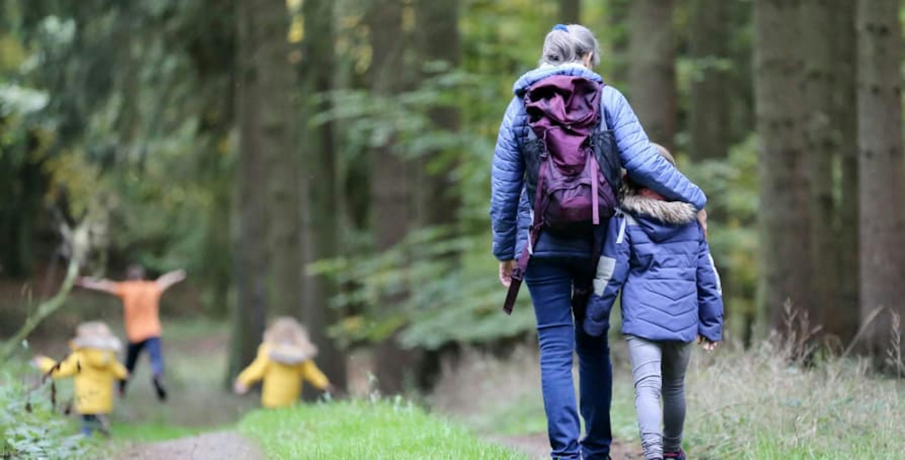 parent and child walking together in the woods