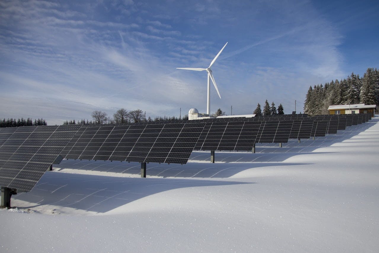 Panneaux solaires sur la neige avec éolienne