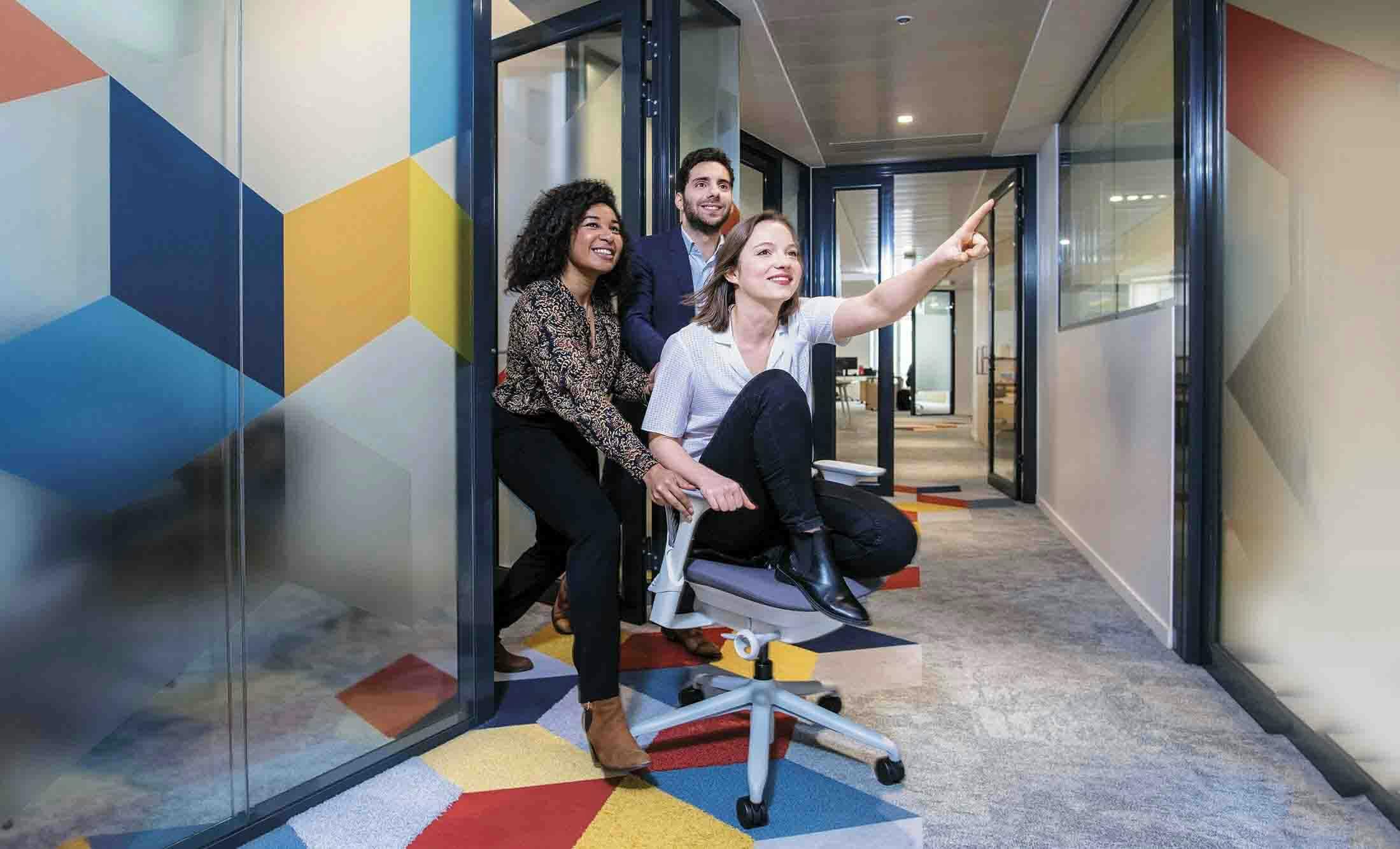 Trois personnes dans le bureau qui sourient