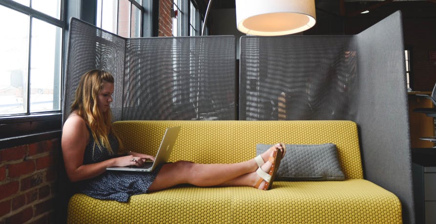 woman working on hotel couch