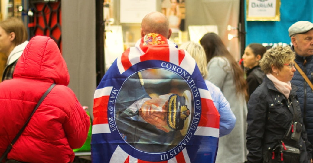 un homme portant un drapeau avec la photo de charles iii
