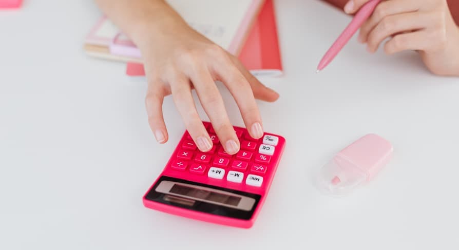 hands using small pink calculator 
