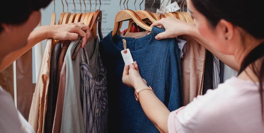 people checking price tag of a blue shirt