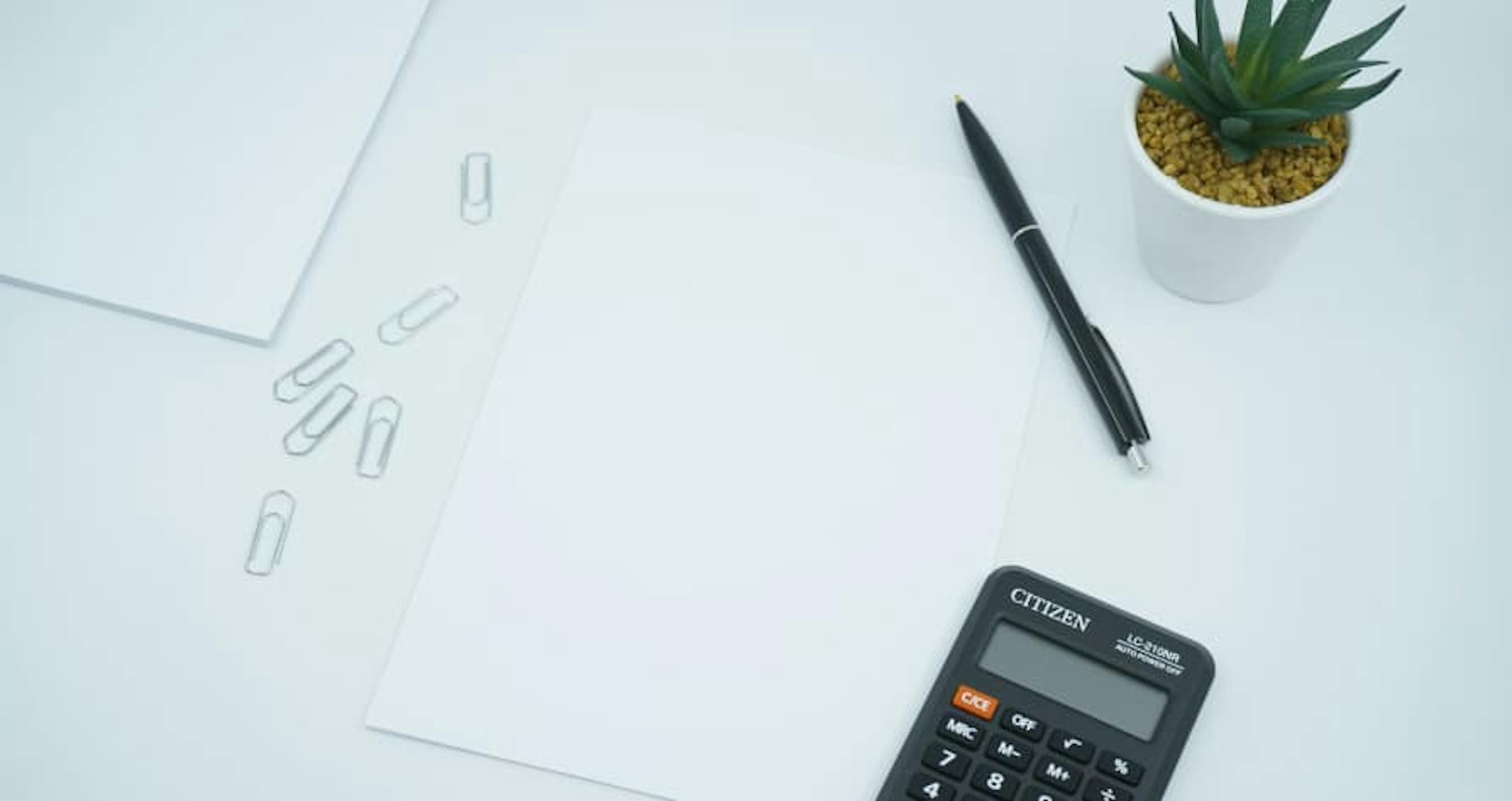 calcualtor notepad and potted plant