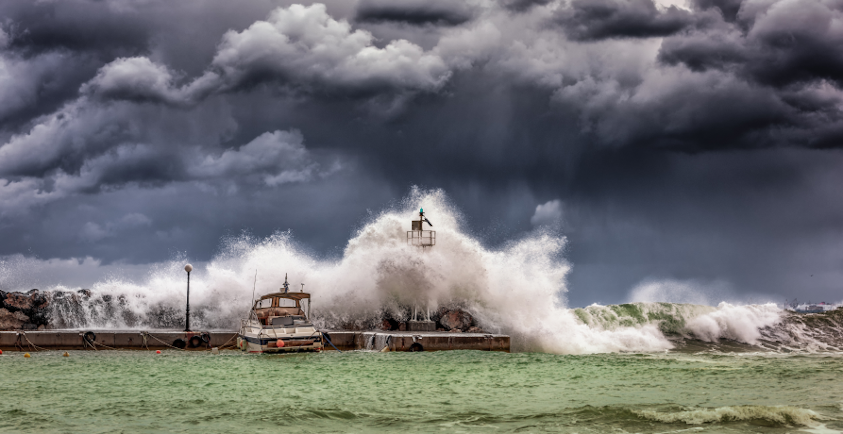 big waves crashing into pier