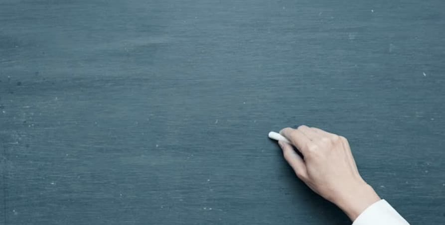 White chalk in hand in front of backboard