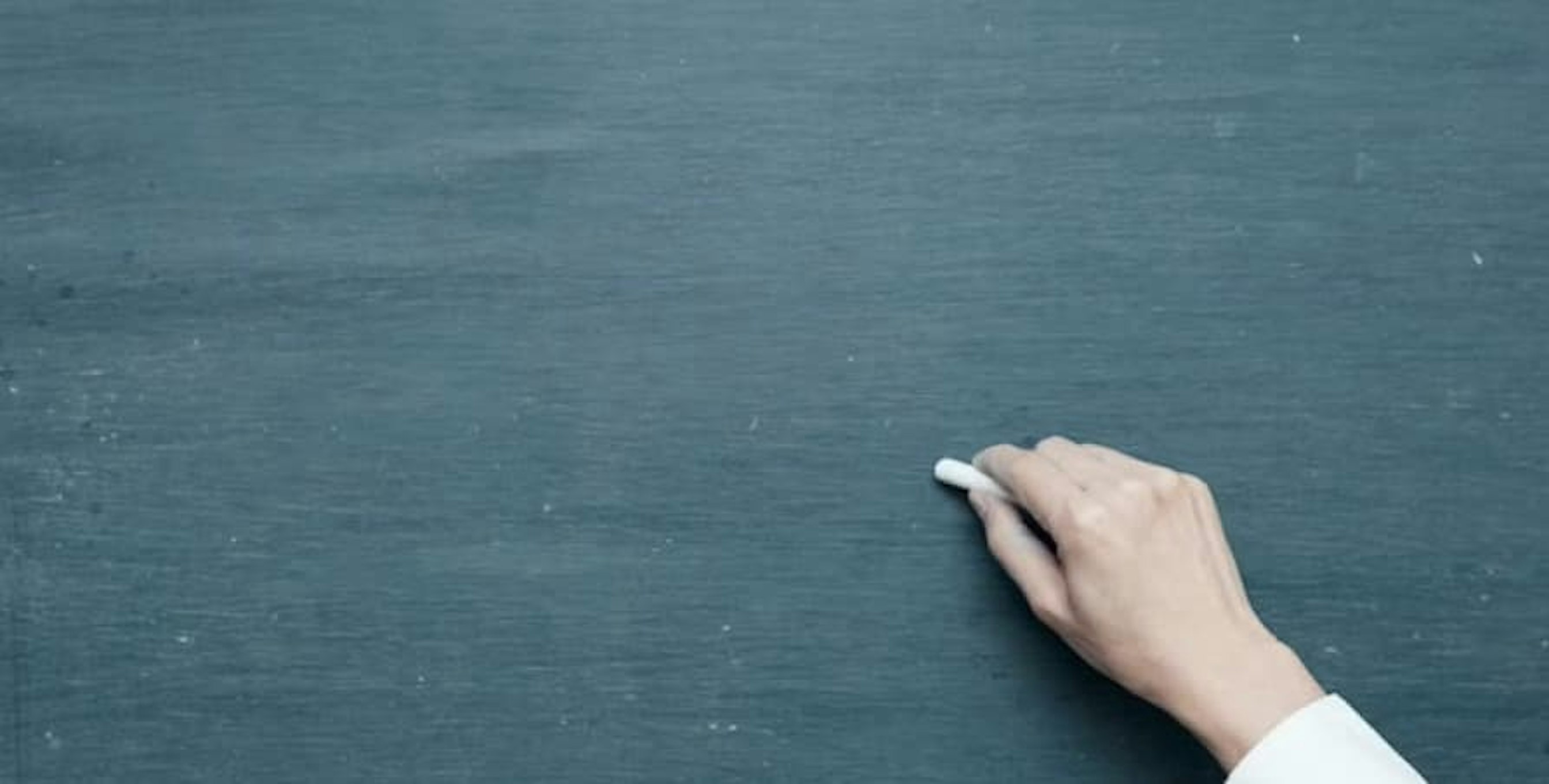 White chalk in hand in front of backboard