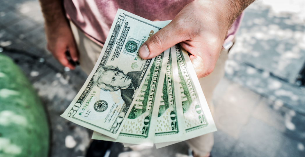 person holding $20 USD bills