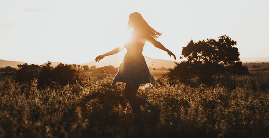 women with sunlight behind her in field