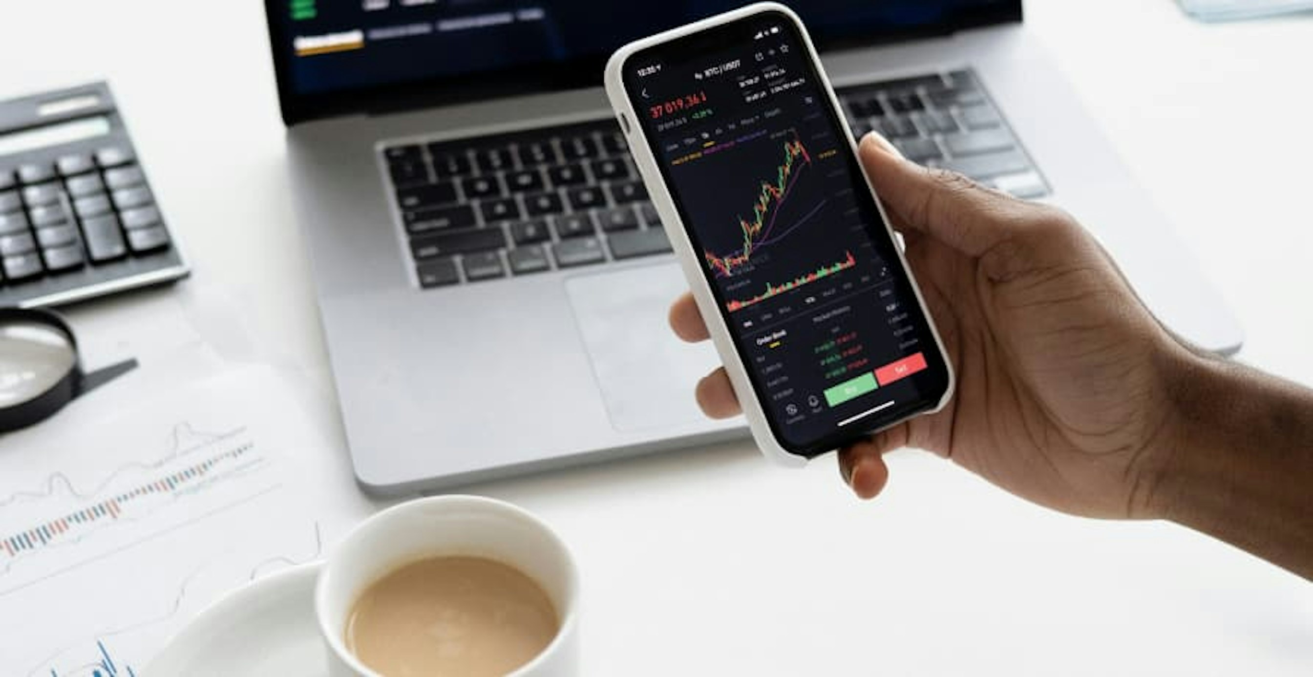 person holding a phone with investing data