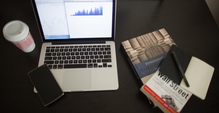 laptop, coffee, and wall street journal book
