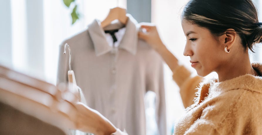 une femme choisissant des vêtements en magasin