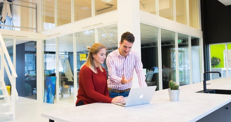 two people looking at a laptop