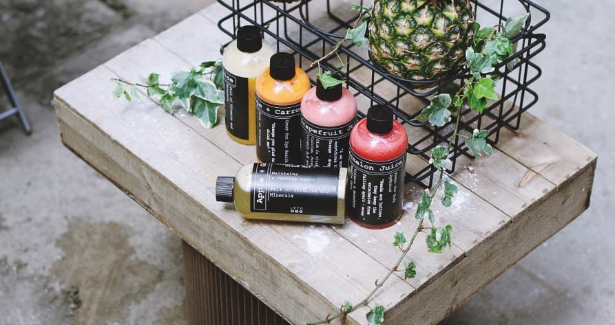 colorful shampoos on wooden table with pineapple