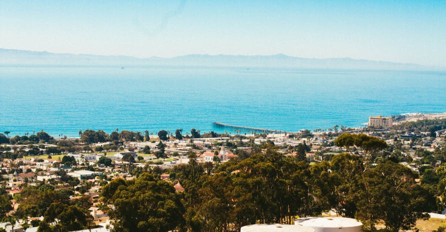 teal water view with mountains in background and beach houses