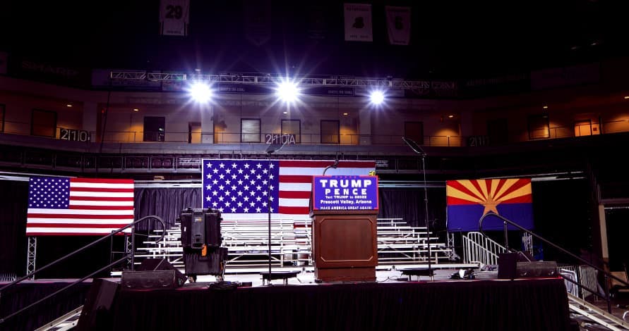 trump pence podium and american flags with stadium lights