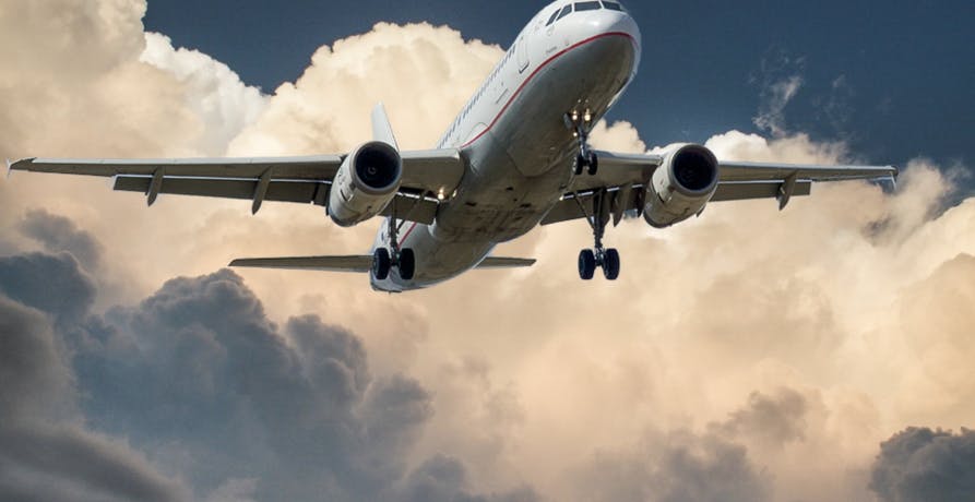 plane flying in the air with clouds