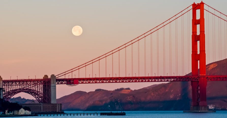 golden gate bridge at dusk with view of moon