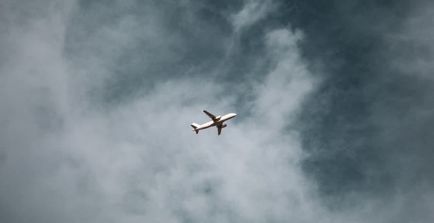 plane flying overhead through some clouds