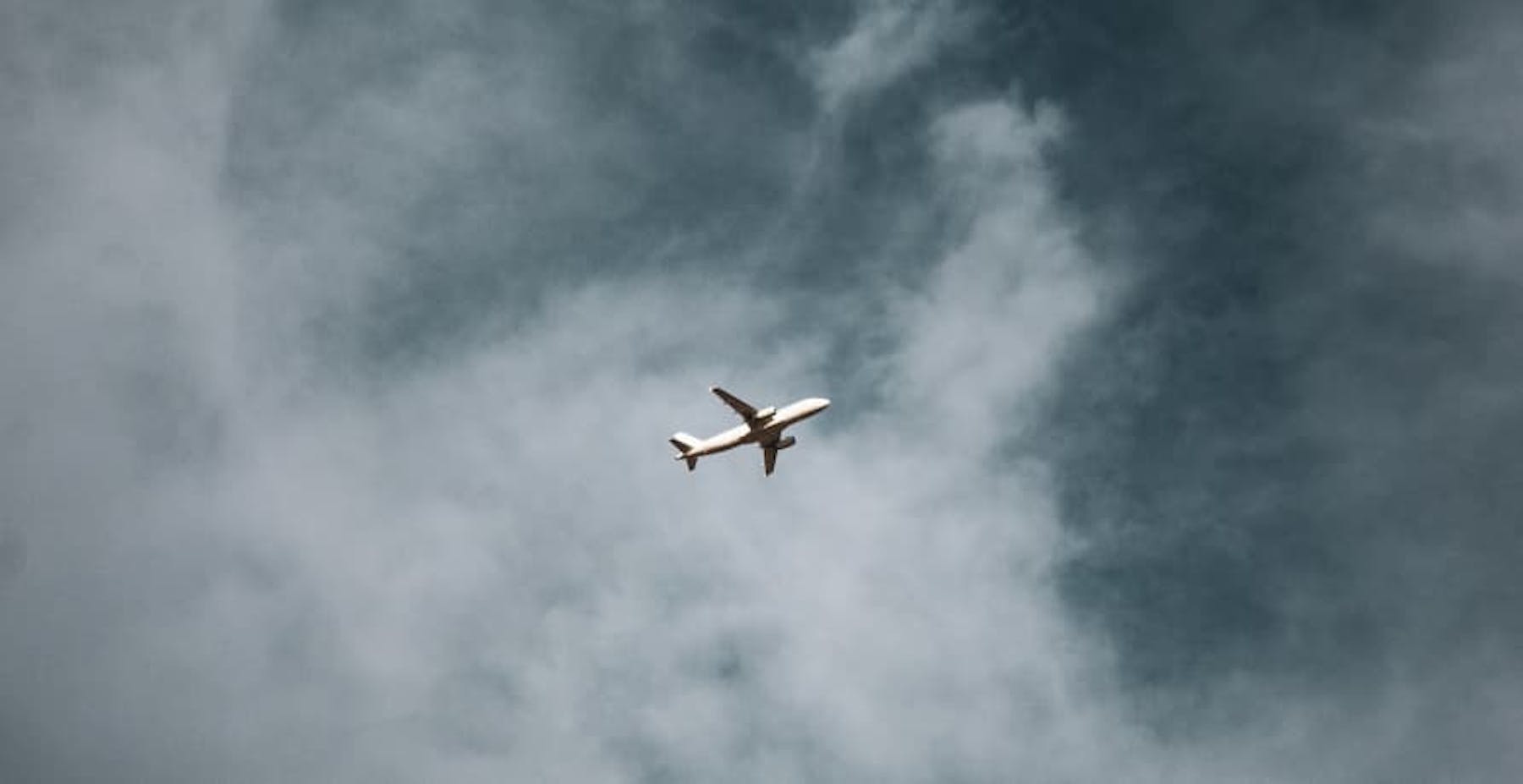 plane flying in cloudy sky