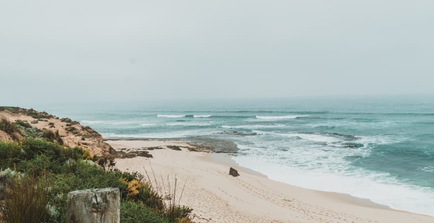 coastal view on beach shorline teal water hazy sky