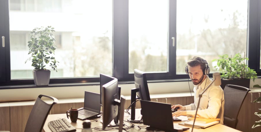 Homme consultant son ordinateur dans un open space