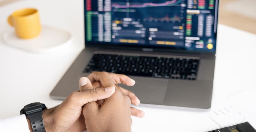 man sitting in front of laptop which shows investment performance