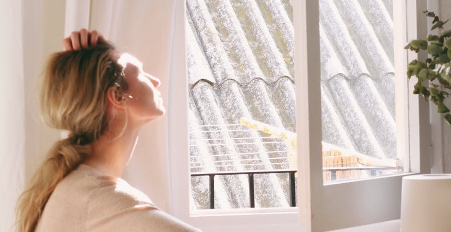 femme devant fenêtre ouverte