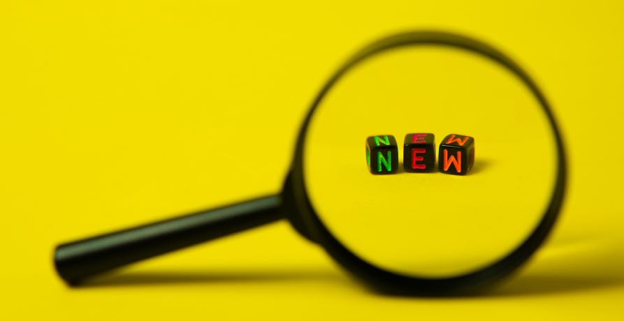 loupe sur dés formant le mot "new"