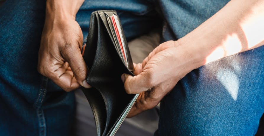 Un homme montrant son portefeuille vide