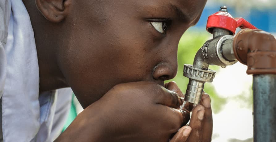 boy drinking water from tap