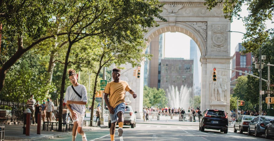 two people walking in summer in washington square park