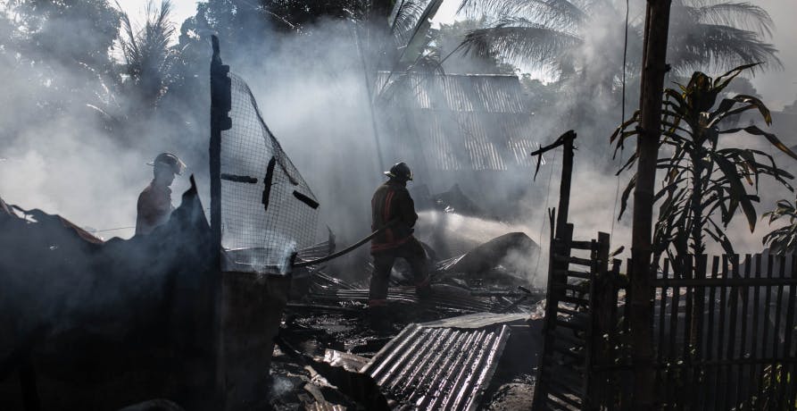 people in destroyed costal house dark clouds