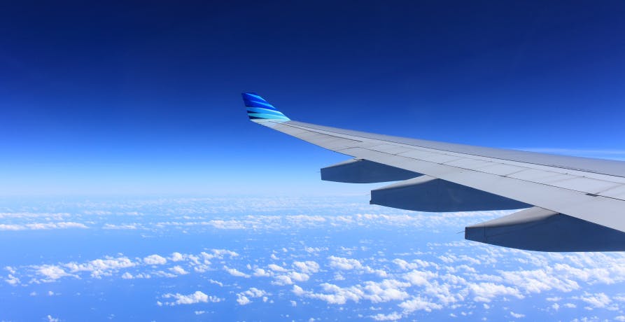 plane wing flying in clear blue skies
