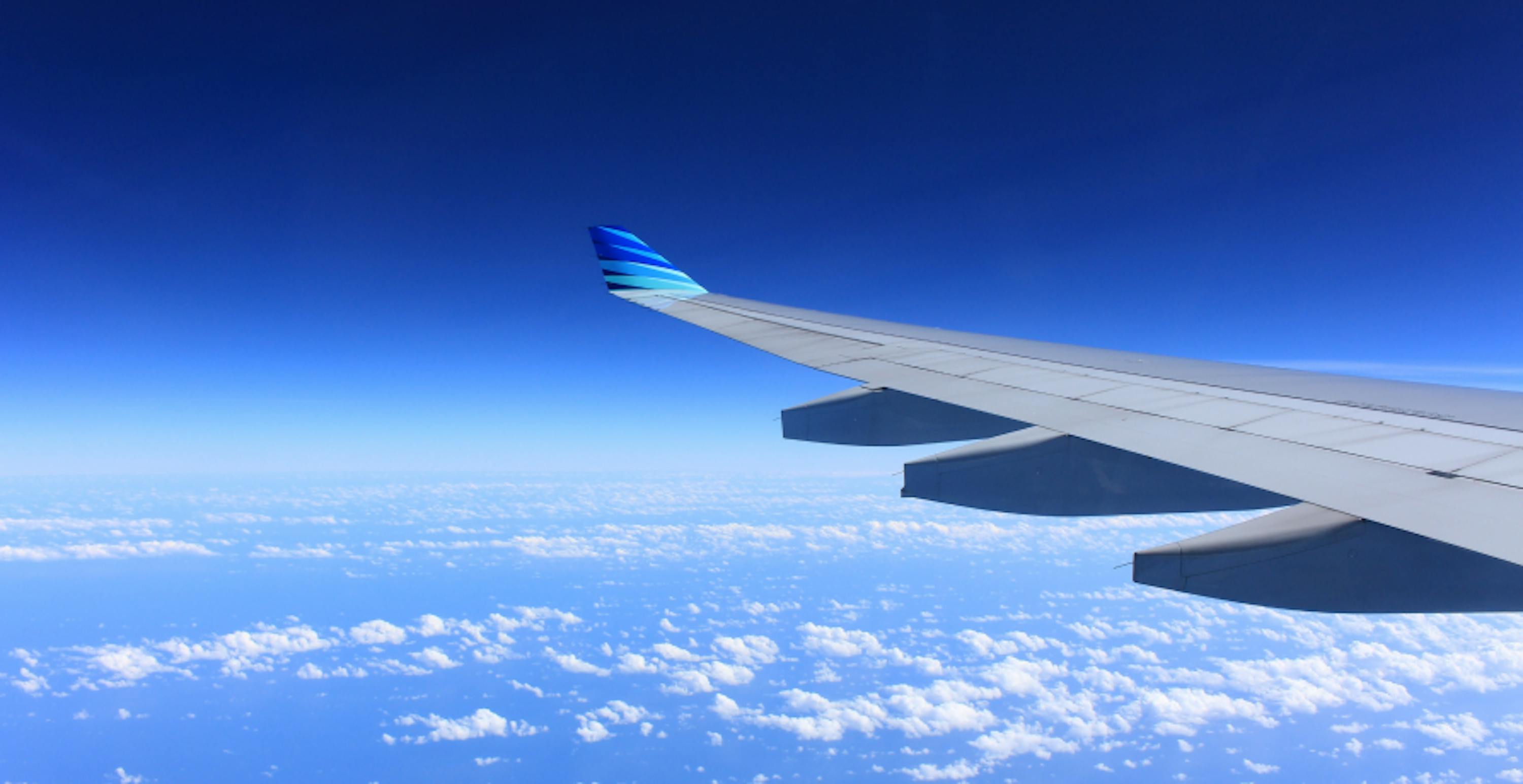 plane wing flying in clear blue skies