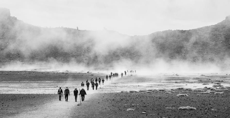 un groupe de personnes marchant dans un paysage rocheux