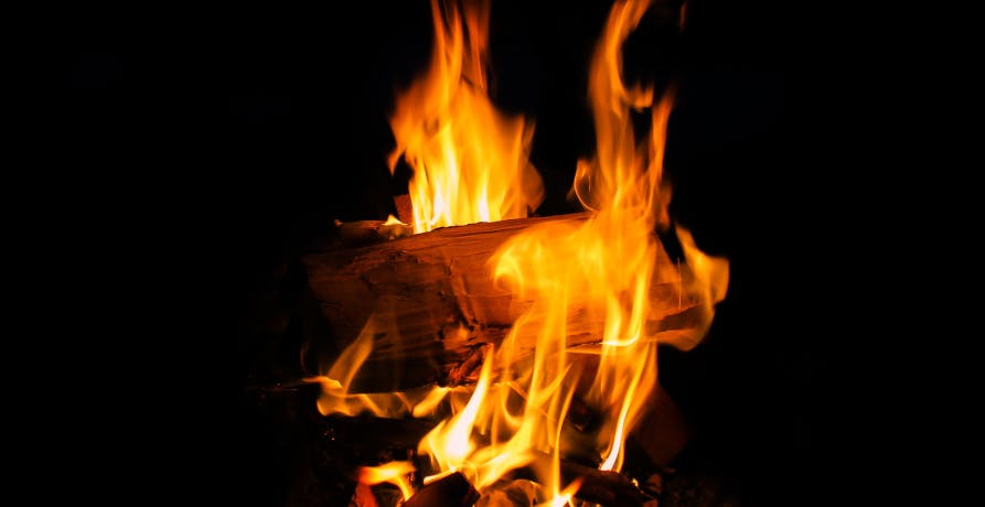 flamme orangée sur une bûche de bois