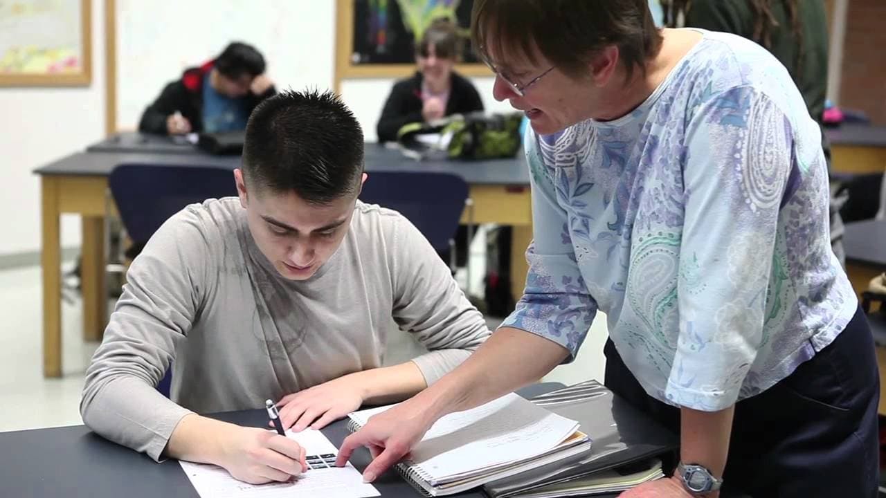 thumbnail person helping someone at desk