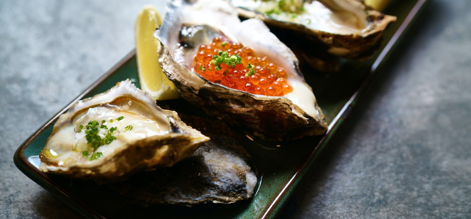 Differently cooked oysters on a rectangular plate