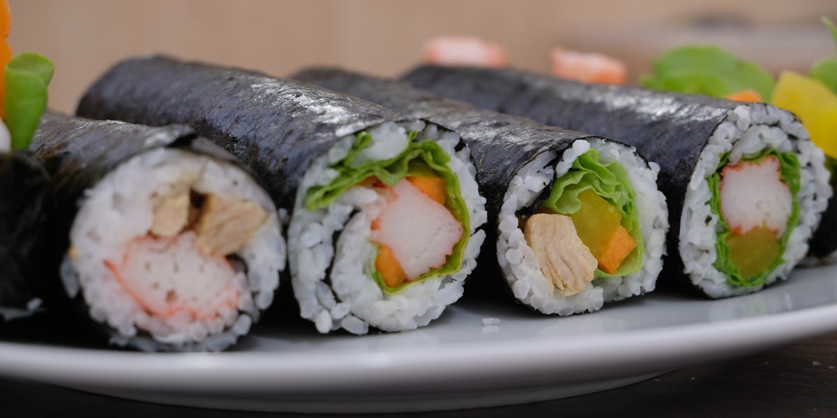 Four sushi rolls displayed on a plate