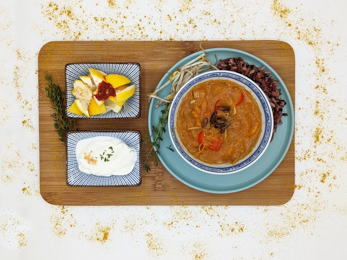 Curry topped with crickets presented in a bowl