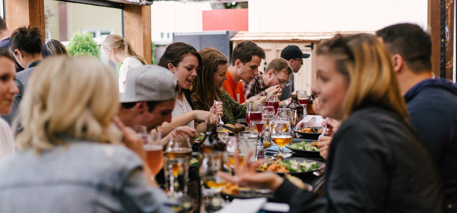 Group of people at a table in a restaurant most likely eating insects too