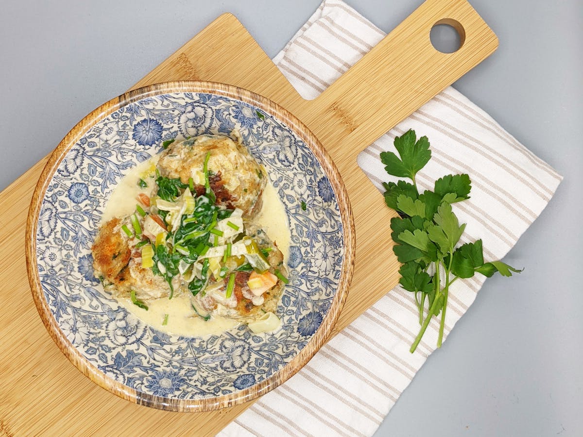 A bowl filled with Cricket dumplings in creamy sauce