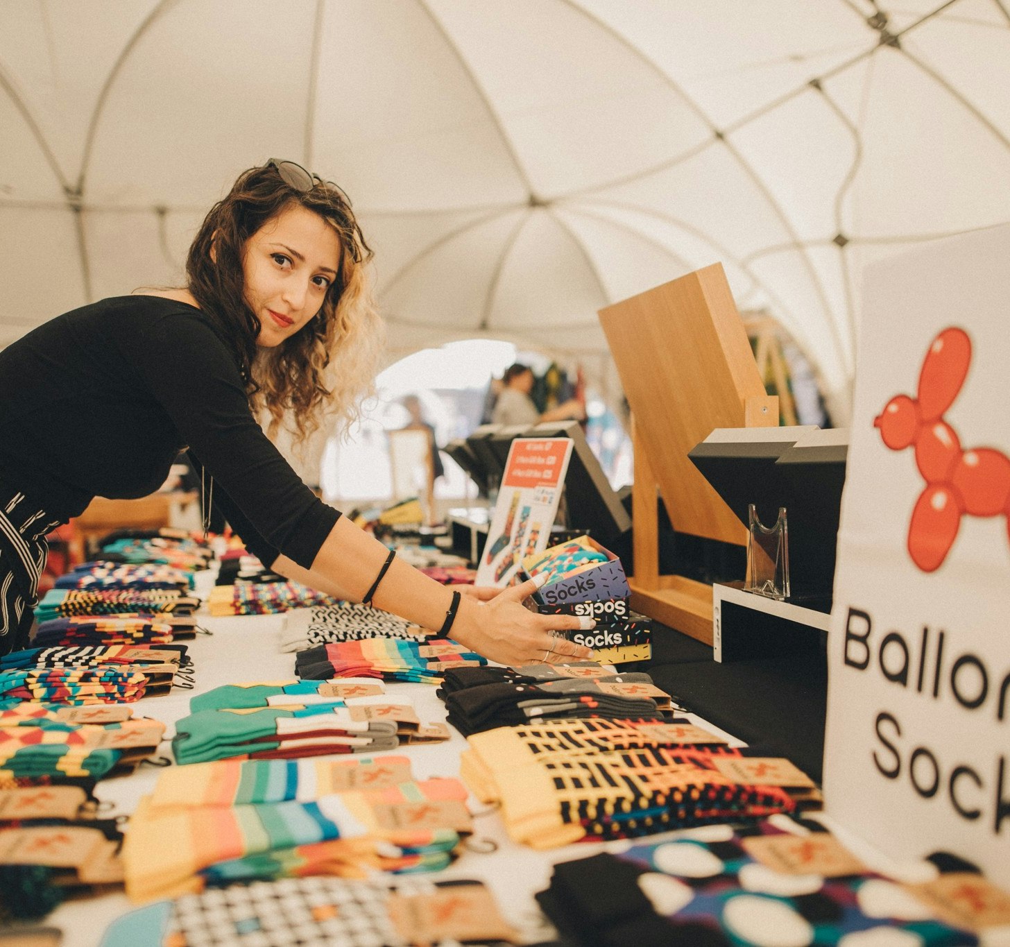 Woman arranging books and socks at a market