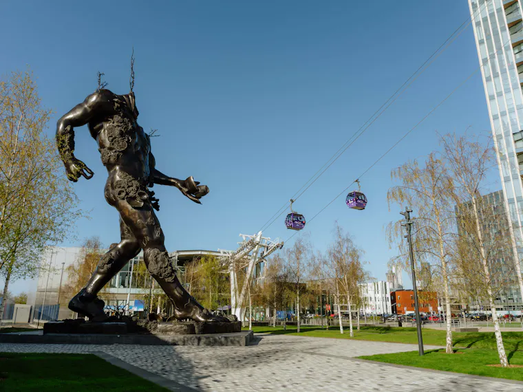 Demon with bowl sculpture with cable cars in the background