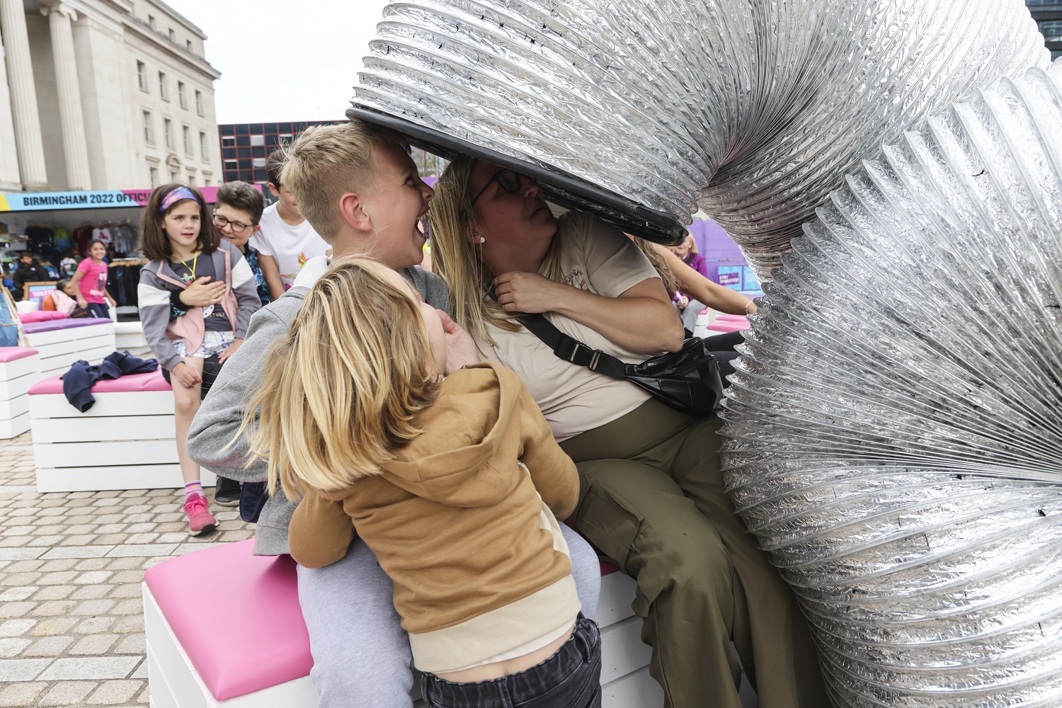 A slinky spring towers over a laughing family