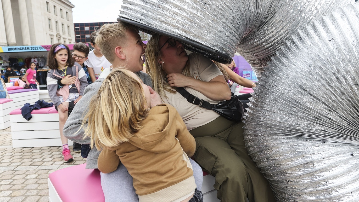 A slinky spring towers over a laughing family