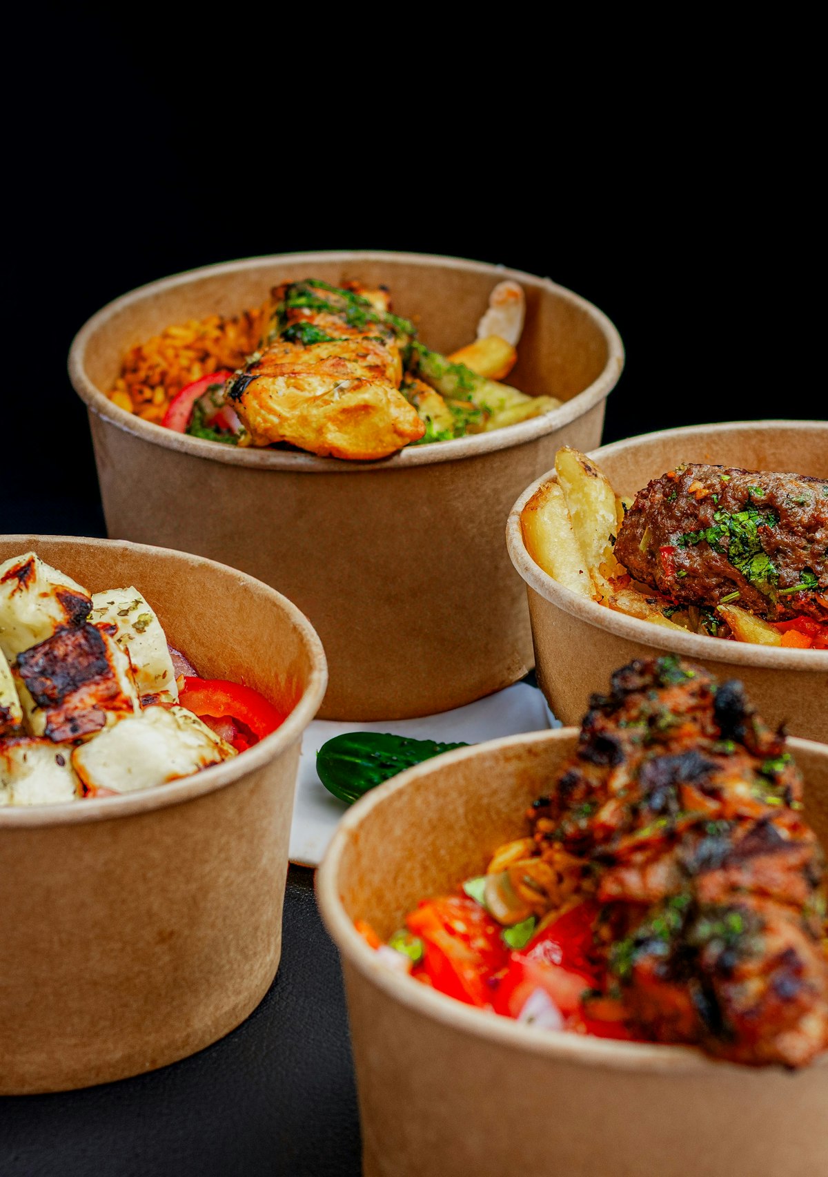 Four takeway tubs of Moroccan food
