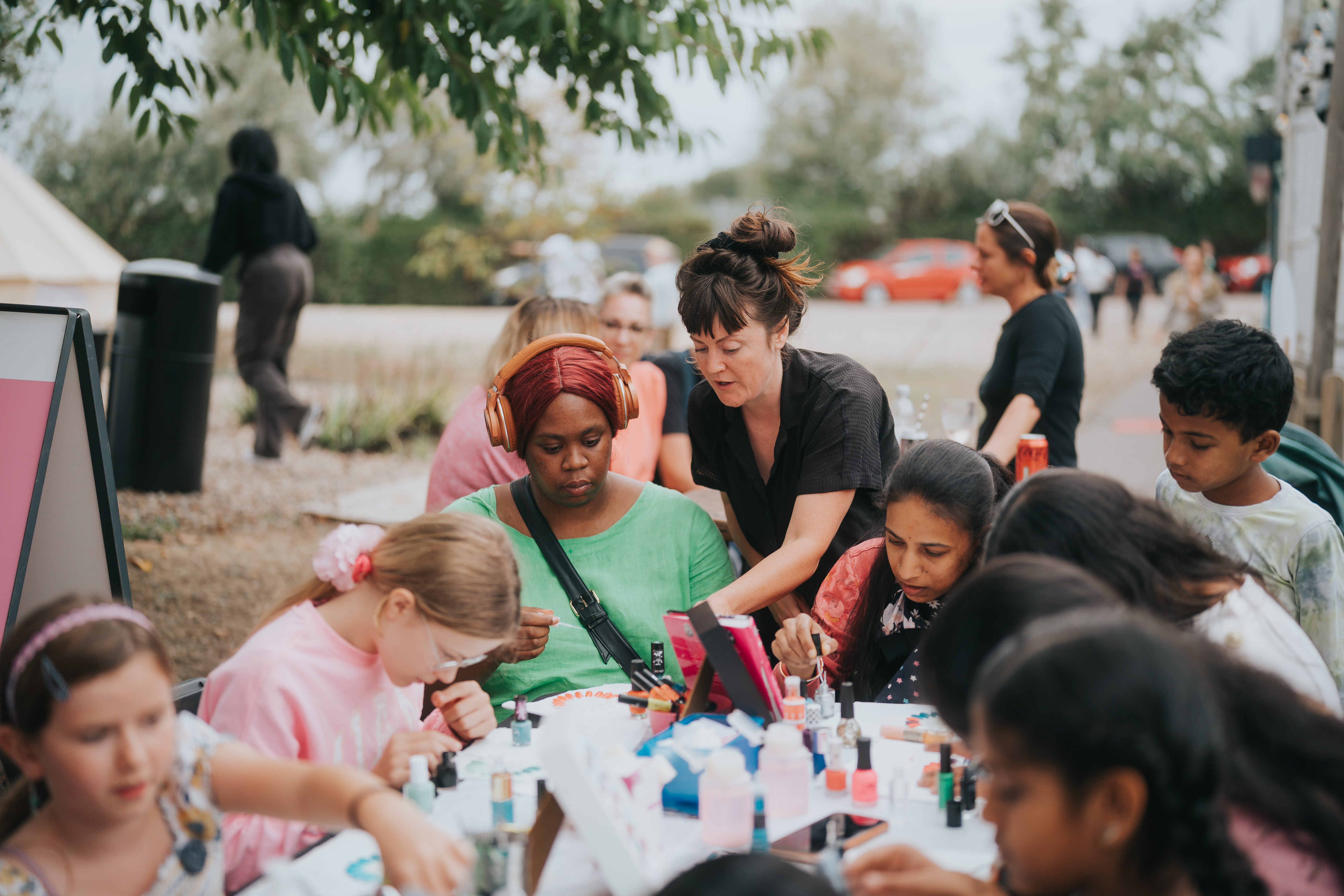 A large group of people having fun making nail art